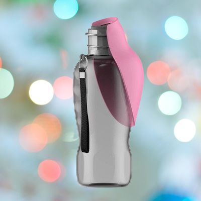Le DogWaterBottle™ - Rose est une bouteille d'eau réutilisable grise dotée d'un couvercle à rabat rose et d'une sangle de transport noire, présentée sur un fond flou avec des lumières bokeh colorées.