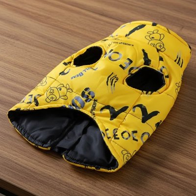 Manteau chien jaune rembourré avec motifs de petits ours, présenté sur une table en bois pour montrer les détails du design.